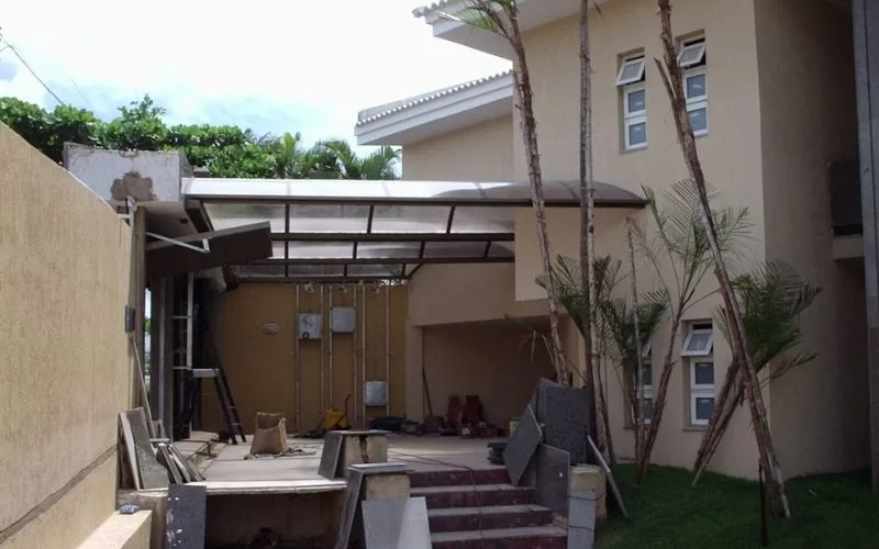 Casa amarela em construção com jardim.