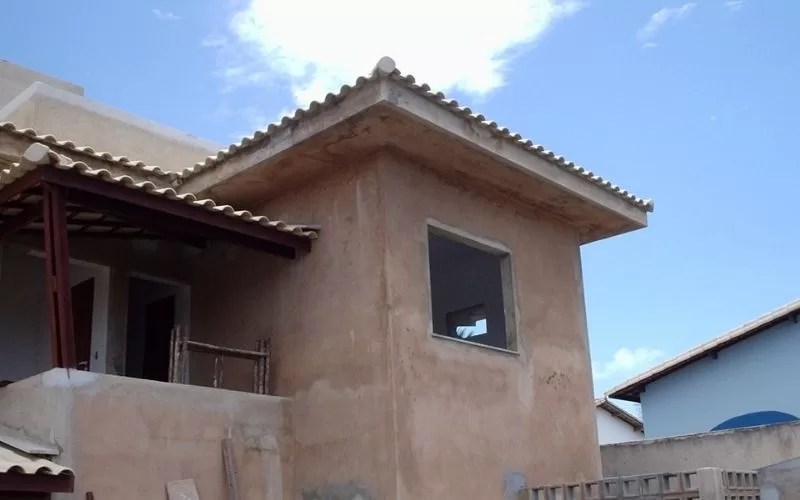Casa em construção com telhado de telhas.