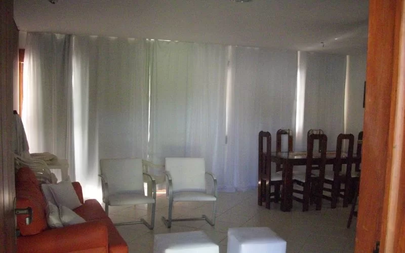 Sala moderna com sofá, cadeiras e mesa de jantar.