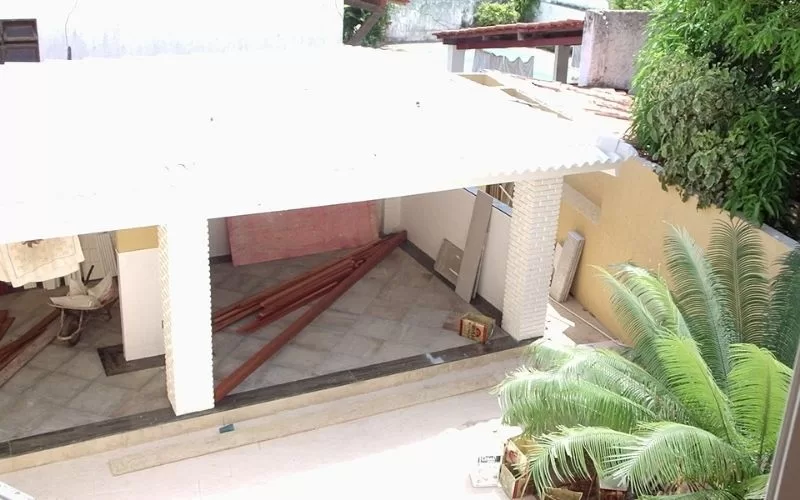 Construção de garagem com plantas ao redor.