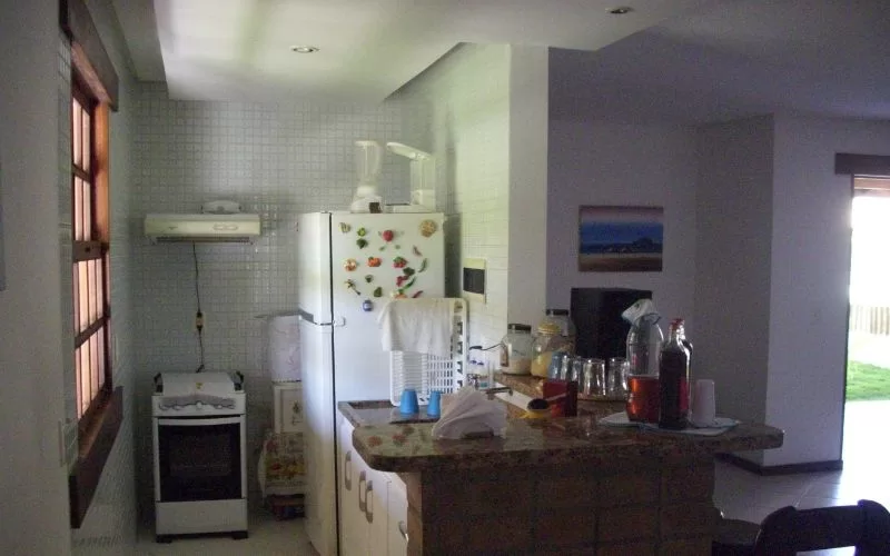 Cozinha pequena com eletrodomésticos e decoração simples.