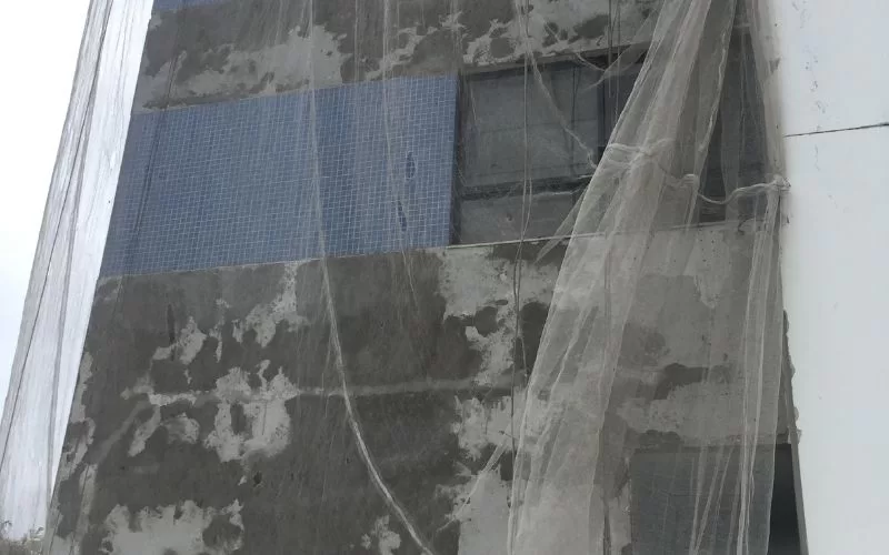 Prédio em reforma coberto por rede de proteção.