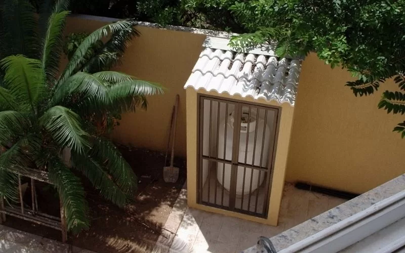 Cilindro de gás em abrigo no jardim.