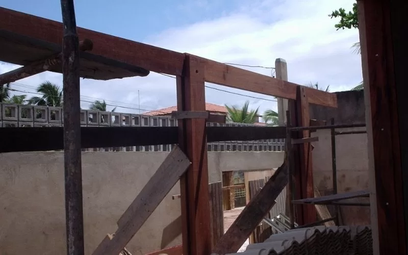 Construção com andaimes de madeira em área externa.