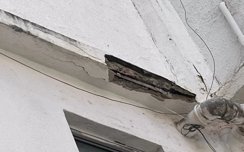 Fachada de prédio com danos na estrutura.