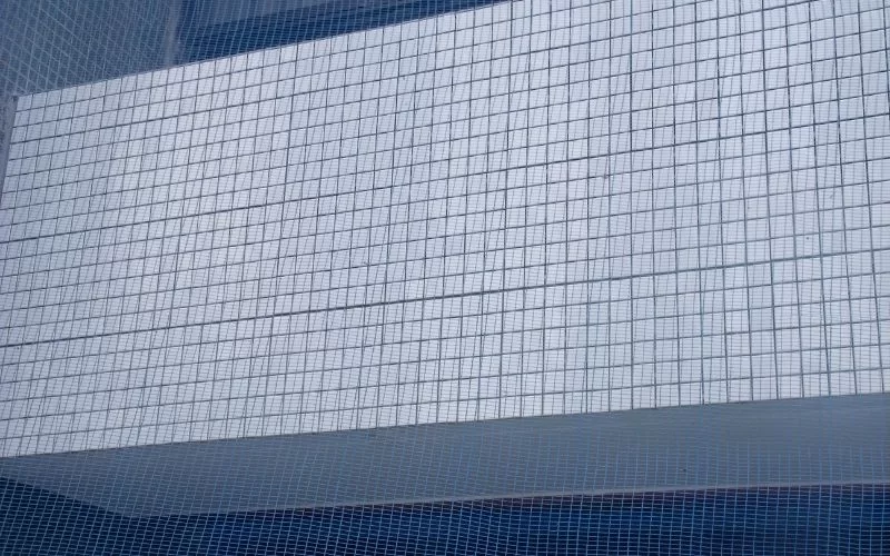 Parede de azulejos brancos refletindo luz.