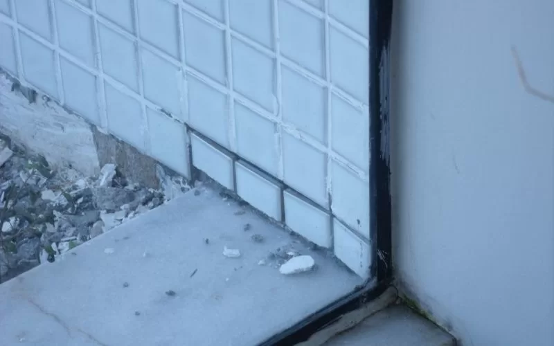 Danos na fachada de azulejos junto ao chão.
