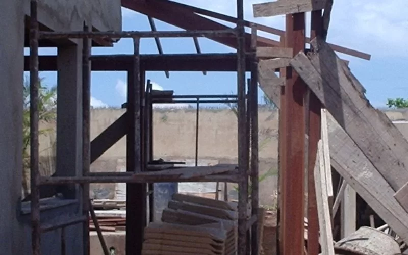 Construção de casa com andaimes e materiais empilhados