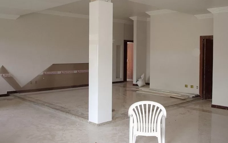 Sala vazia com cadeira de plástico branca.