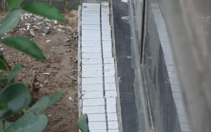 Azulejos brancos junto a janela e jardim