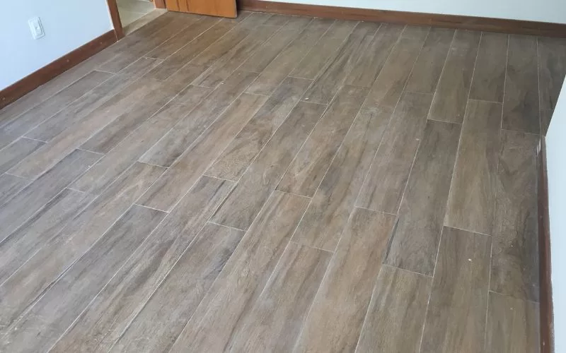 Piso de madeira em sala vazia.