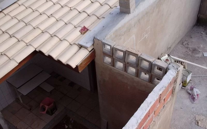 Vista aérea de obra com telhado e paredes em construção.