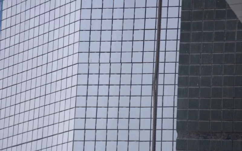 Reflexo de janelas em prédio moderno.