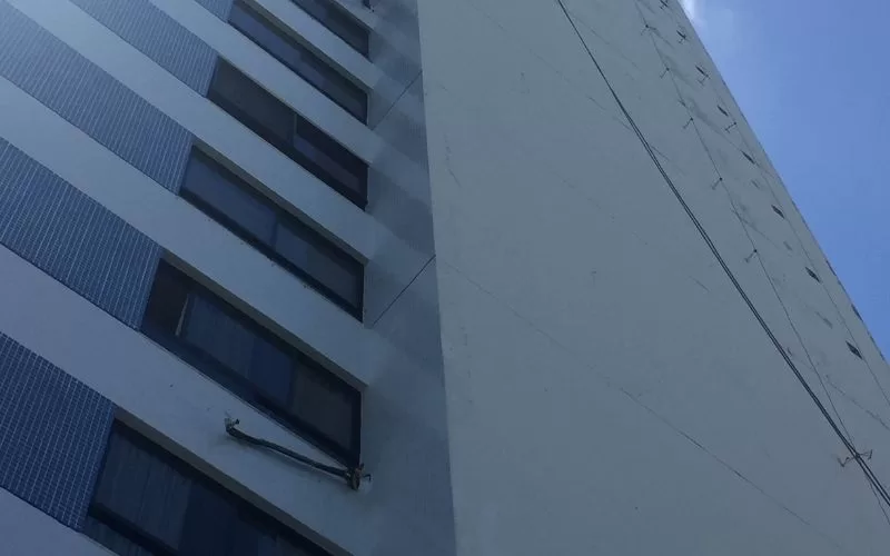 Fachada de prédio alto em azul e branco.