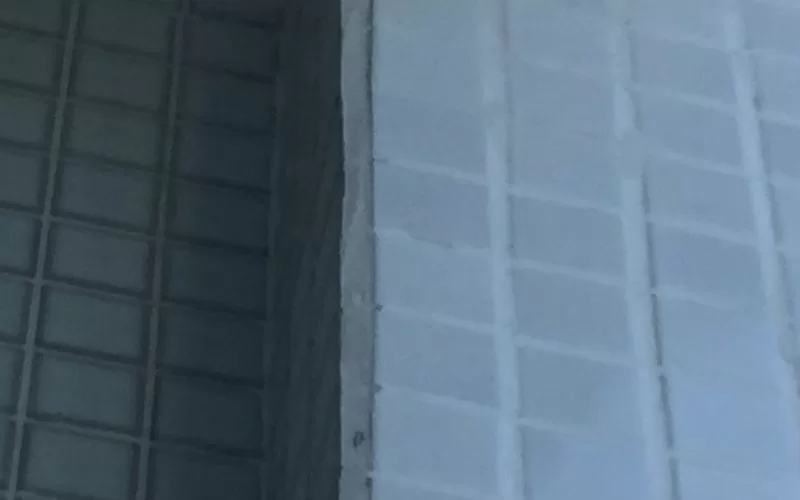 Parede de azulejos brancos em edifício moderno.