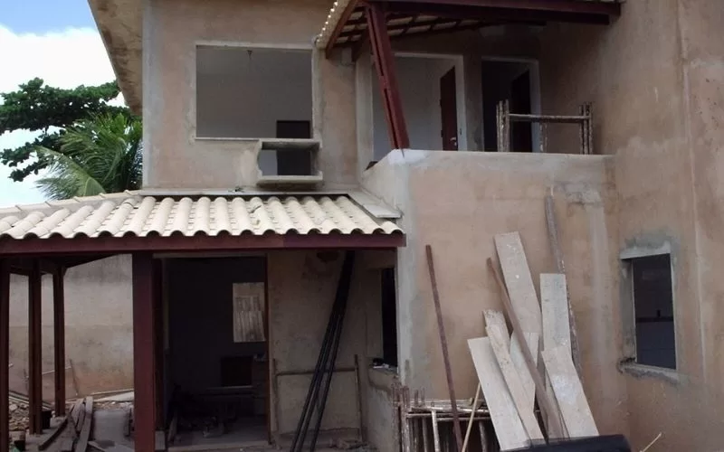 Casa em construção com materiais ao redor.