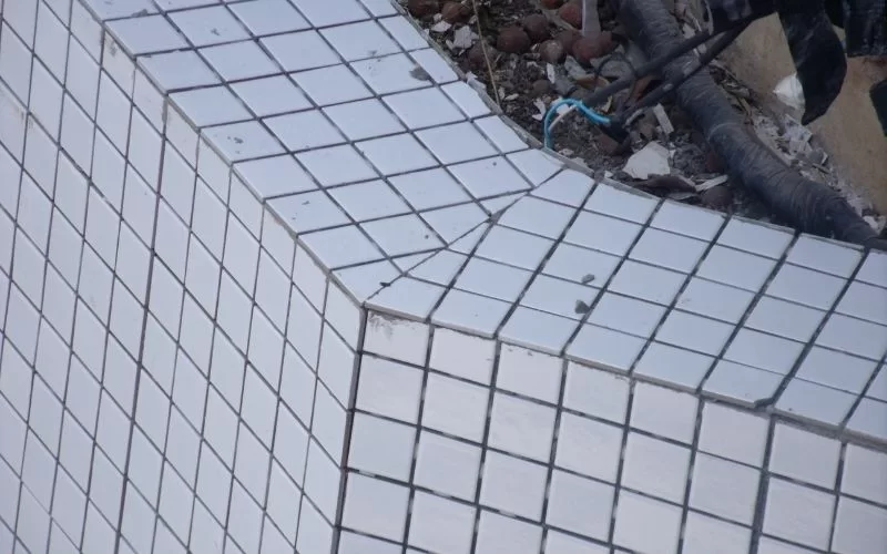 Pastilhas brancas em superfície inclinada.