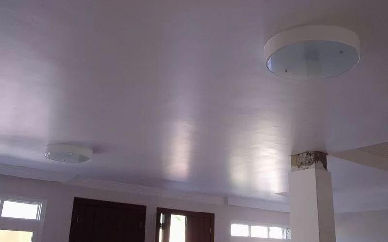 Teto branco com luzes embutidas e janelas.