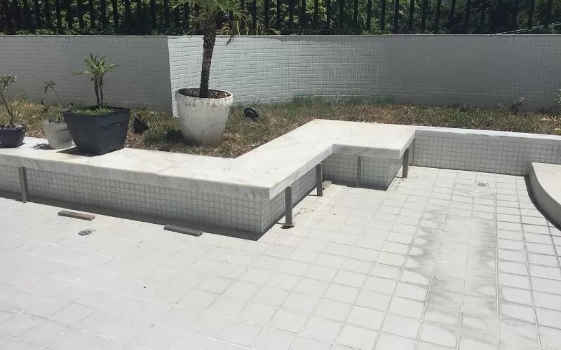 Banco de jardim com vasos de plantas.