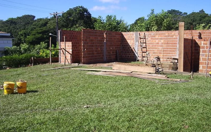 Construção de parede em tijolo vermelho ao ar livre.