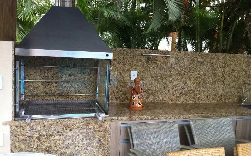 Churrasqueira moderna em espaço ao ar livre com plantas.
