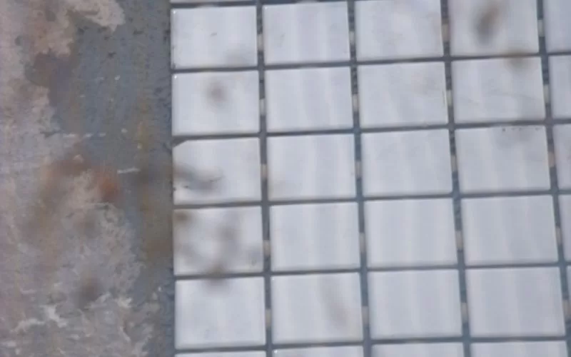 Azulejos brancos em parede desgastada