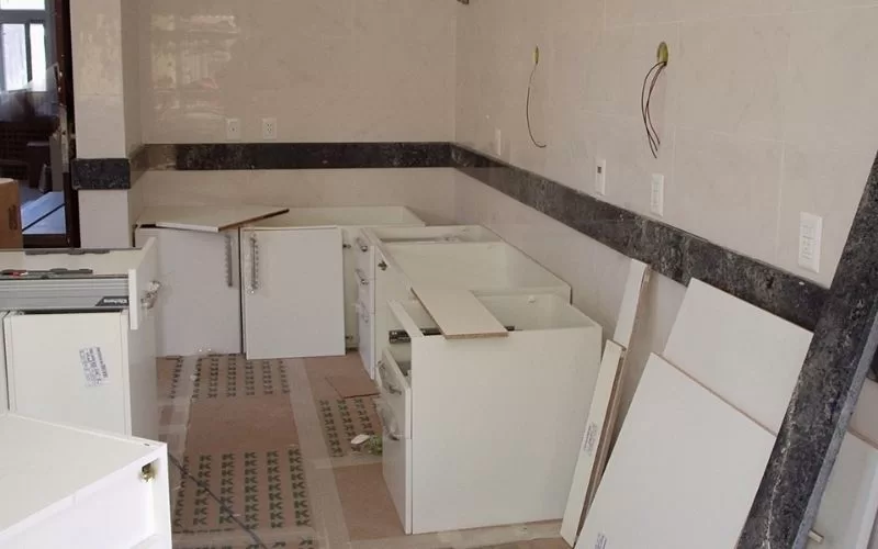 Cozinha em remodelação com armários sem portas.