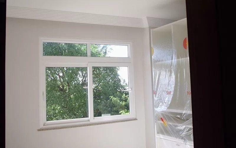 Janela moderna com vista para árvores verdes.