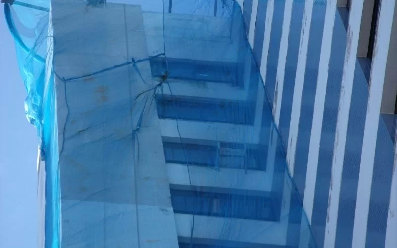 Prédio envolto em rede de proteção azul