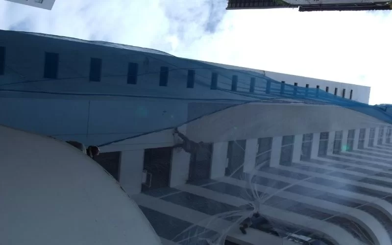 Prédio alto refletido em prédio espelhado azul