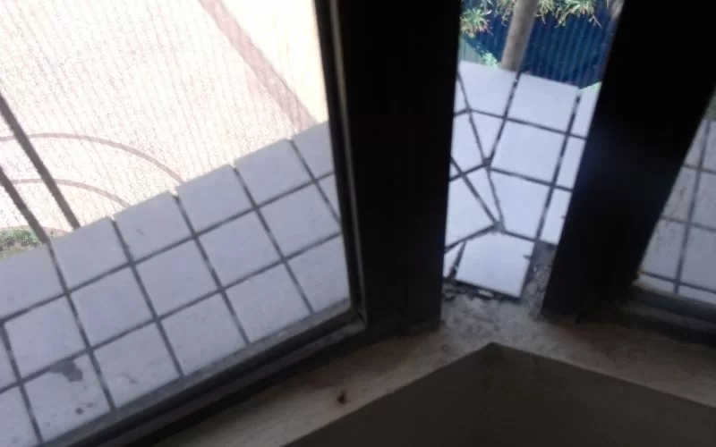 Azulejos quebrados em varanda vista por janela