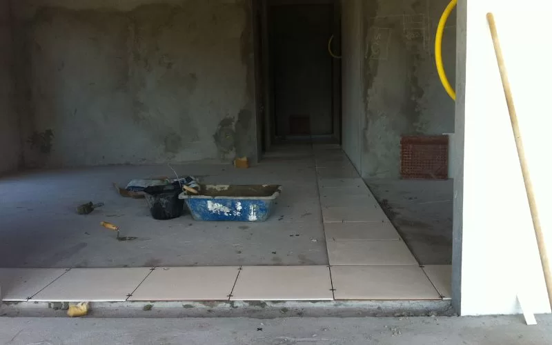 Obra em andamento com azulejos e materiais de construção.