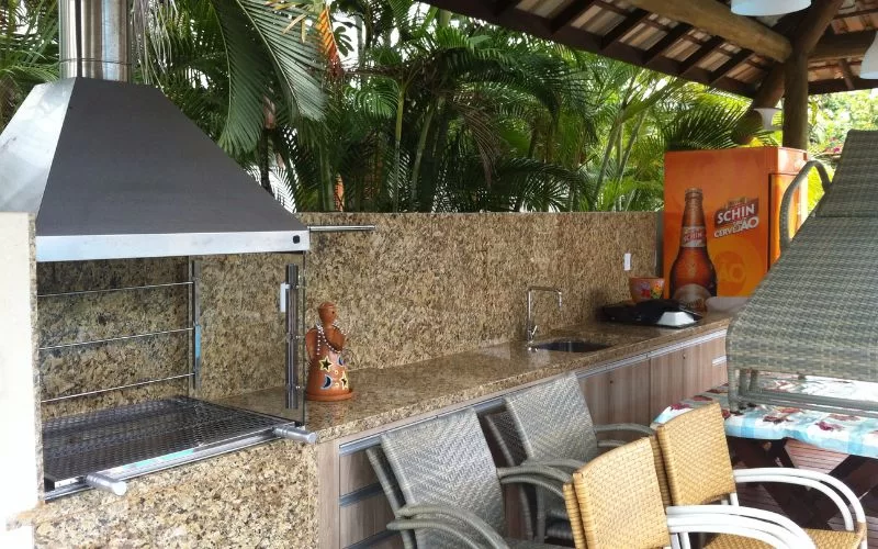 Área de churrasco com pia e cervejeira.