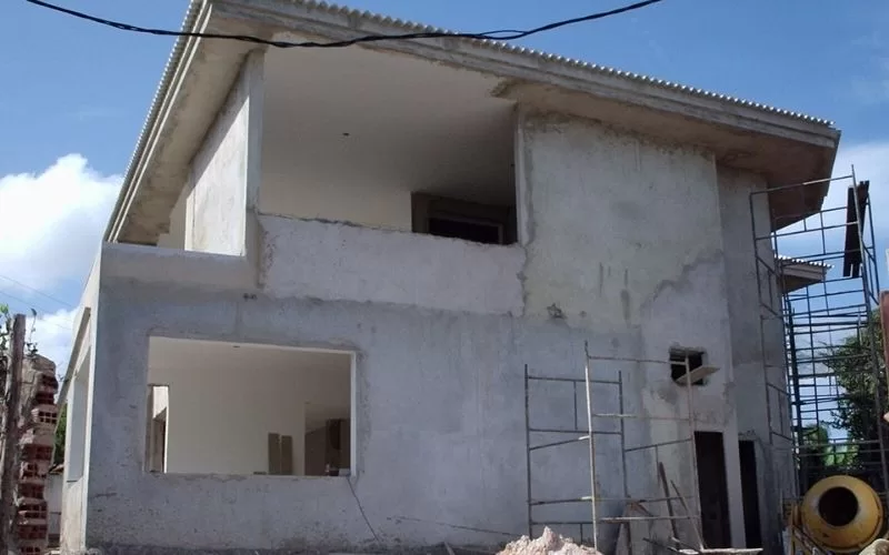 Casa em construção com andaimes à volta.