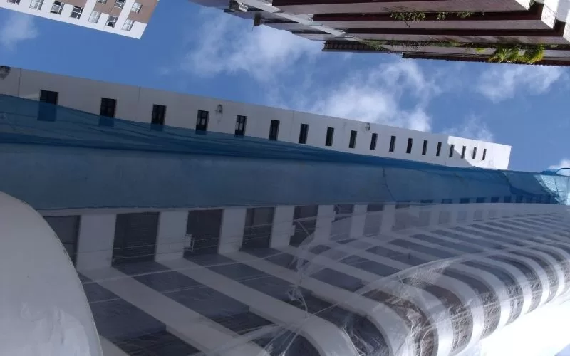 Construção com tela azul em prédio alto.