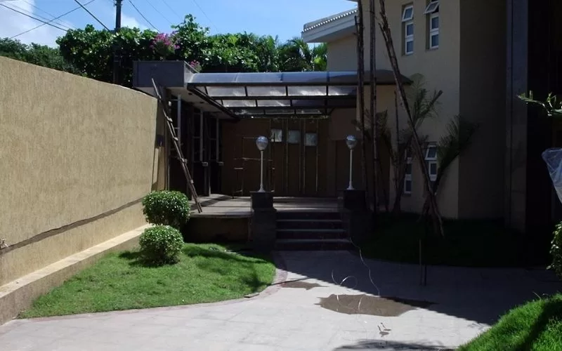 Entrada de casa moderna com jardim e varanda.