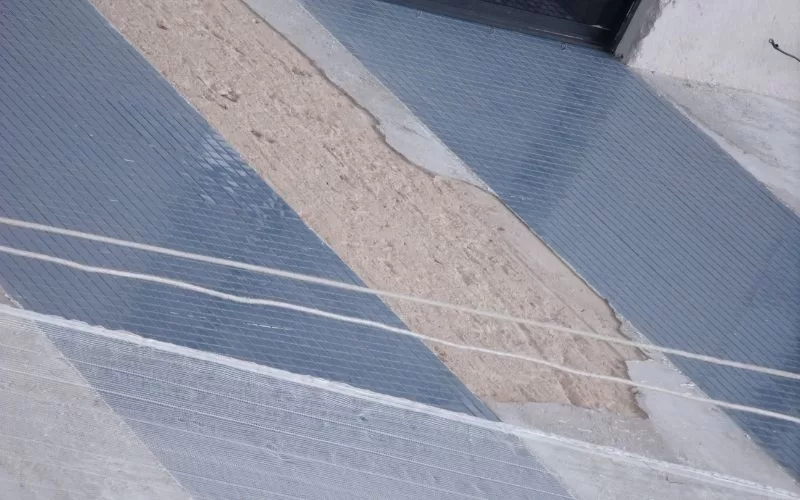 Rampa de cimento inclinada na calçada urbana.