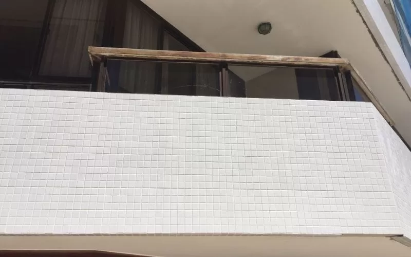 Varanda com revestimento de azulejos brancos.