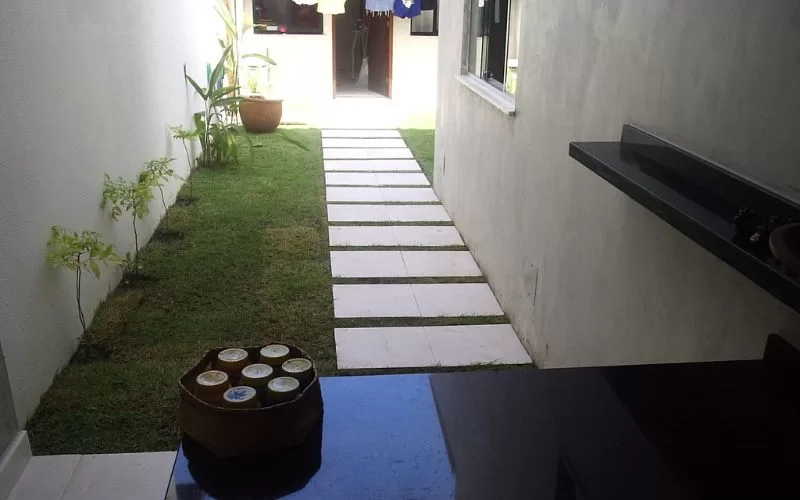 Corredor com jardim e caminho de pedra.