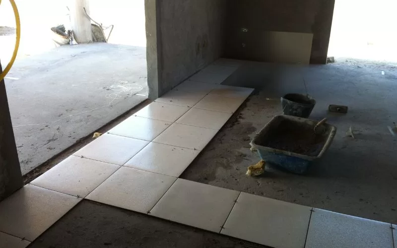 Piso em instalação com azulejos claros.