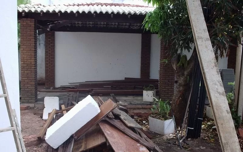 Obras em pátio com material de construção ao lado.
