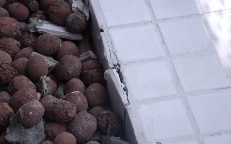 Piso cerâmico danificado com argila expandida visível