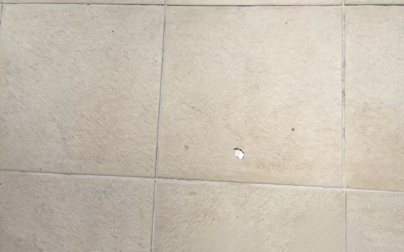 Azulejo com pequeno furo no centro.