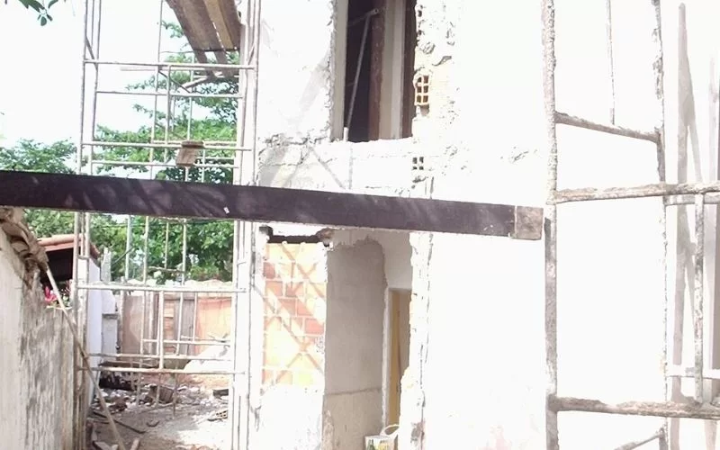 Construção de edifício com andaimes e materiais desordenados.