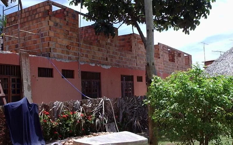 Edifício em construção com paredes de tijolos expostos.