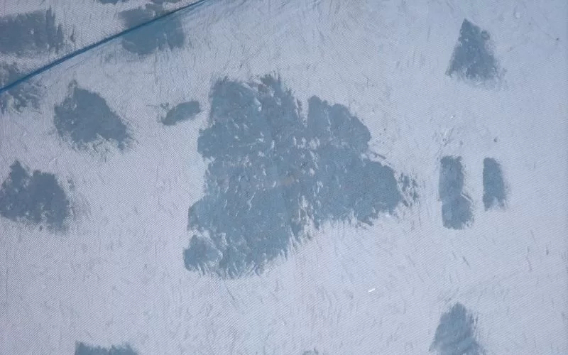 Tecido azul com manchas de tinta acinzentada.