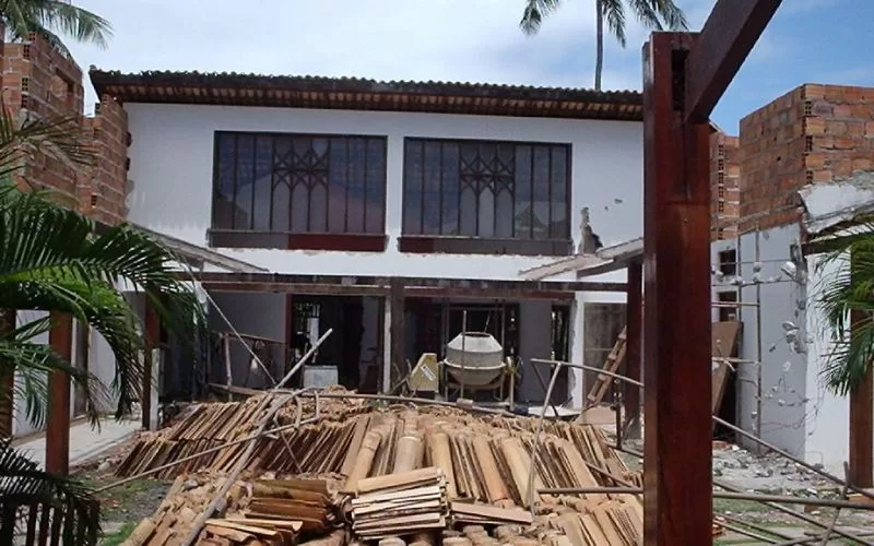 Casa em construção com materiais à frente.