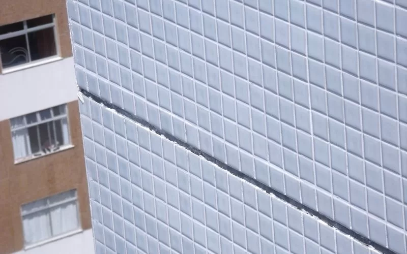 Prédio com azulejos brancos e janelas.