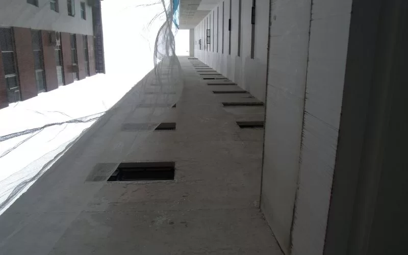 Vista de corredor alto de prédio em construção.