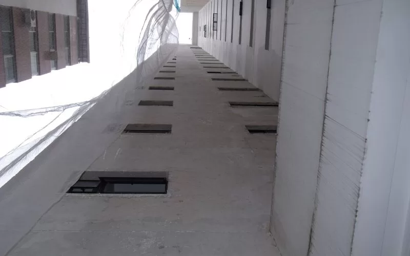 Corredor de edifício com janelas retangulares.